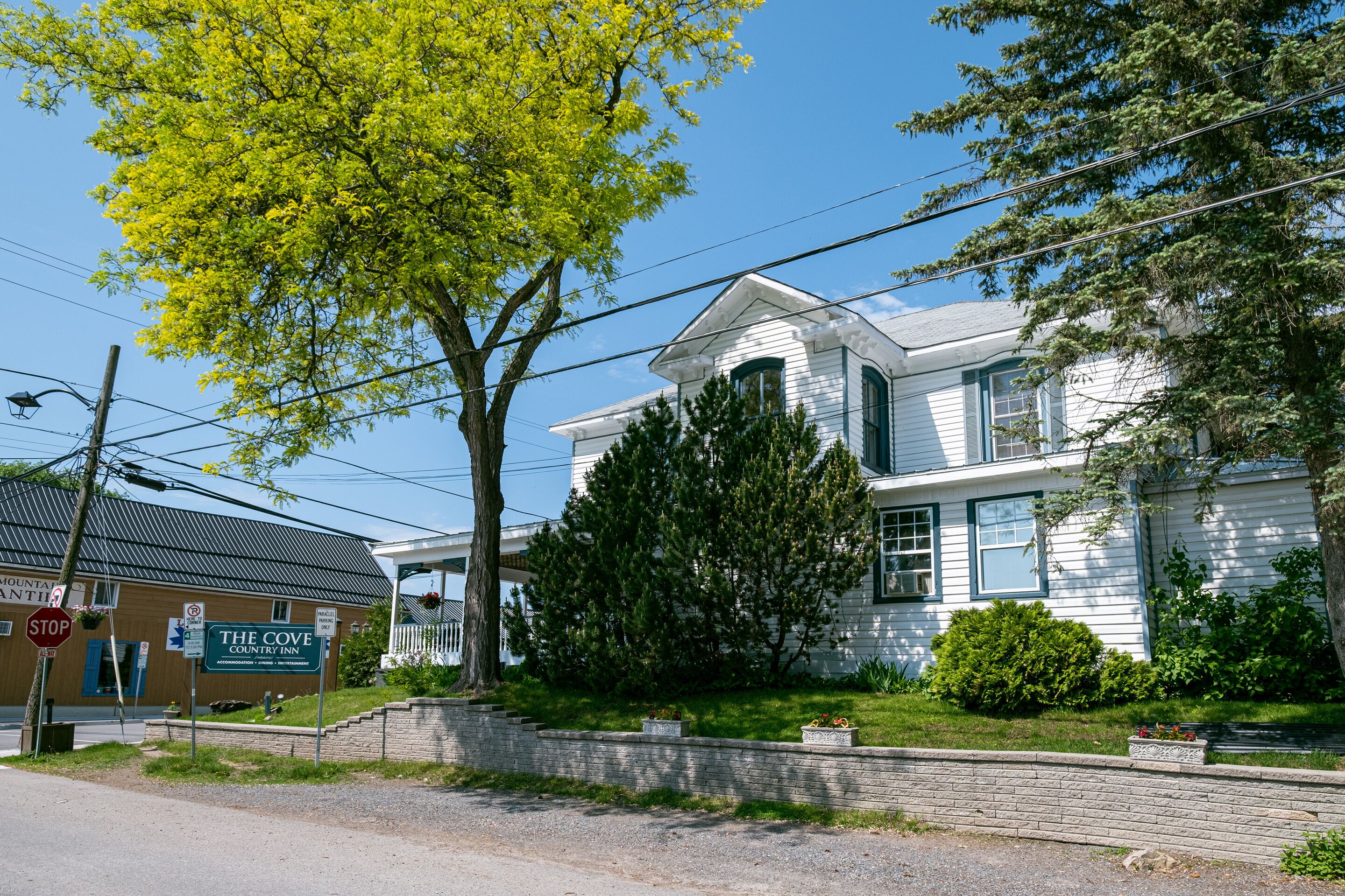 Un edificio blanco de dos pisos con un porche y un letrero que dice 'The Cove Country Inn'.
