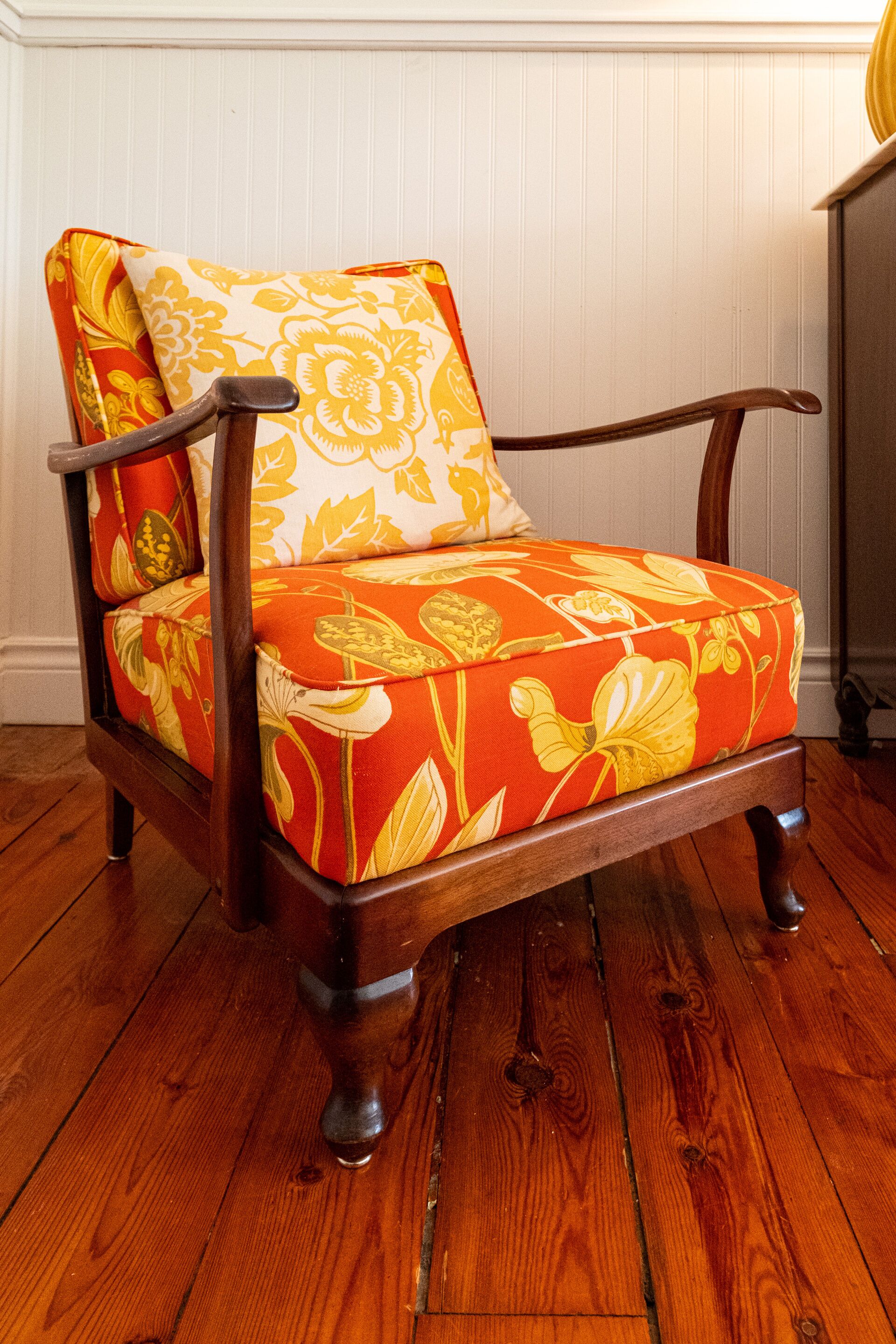 Une chaise en bois avec un coussin à motifs floraux.