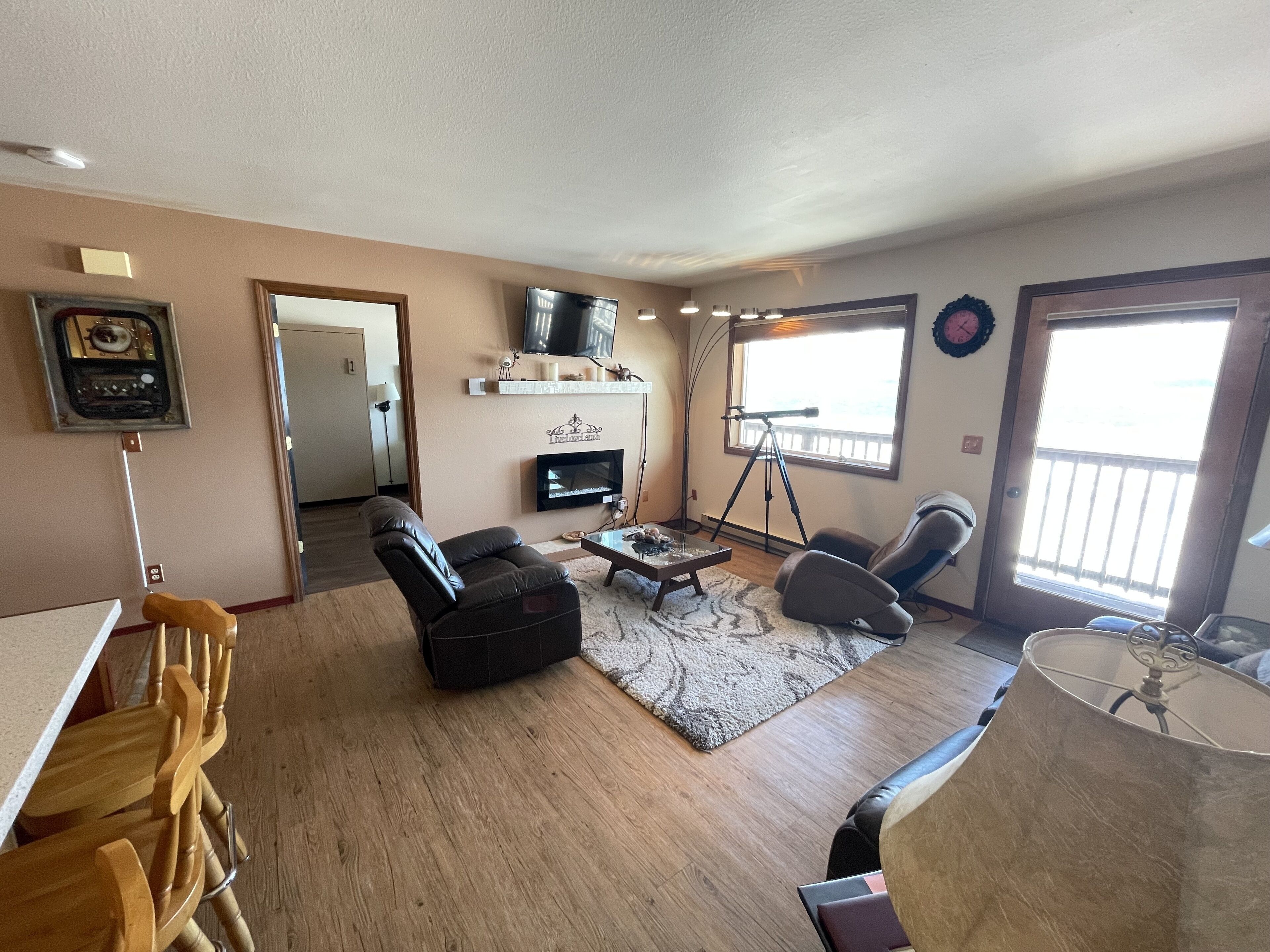 A living room with a fireplace, a television, and a telescope.