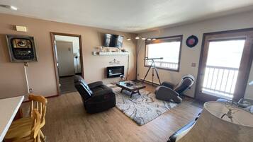 Una sala de estar con chimenea, televisor y telescopio.