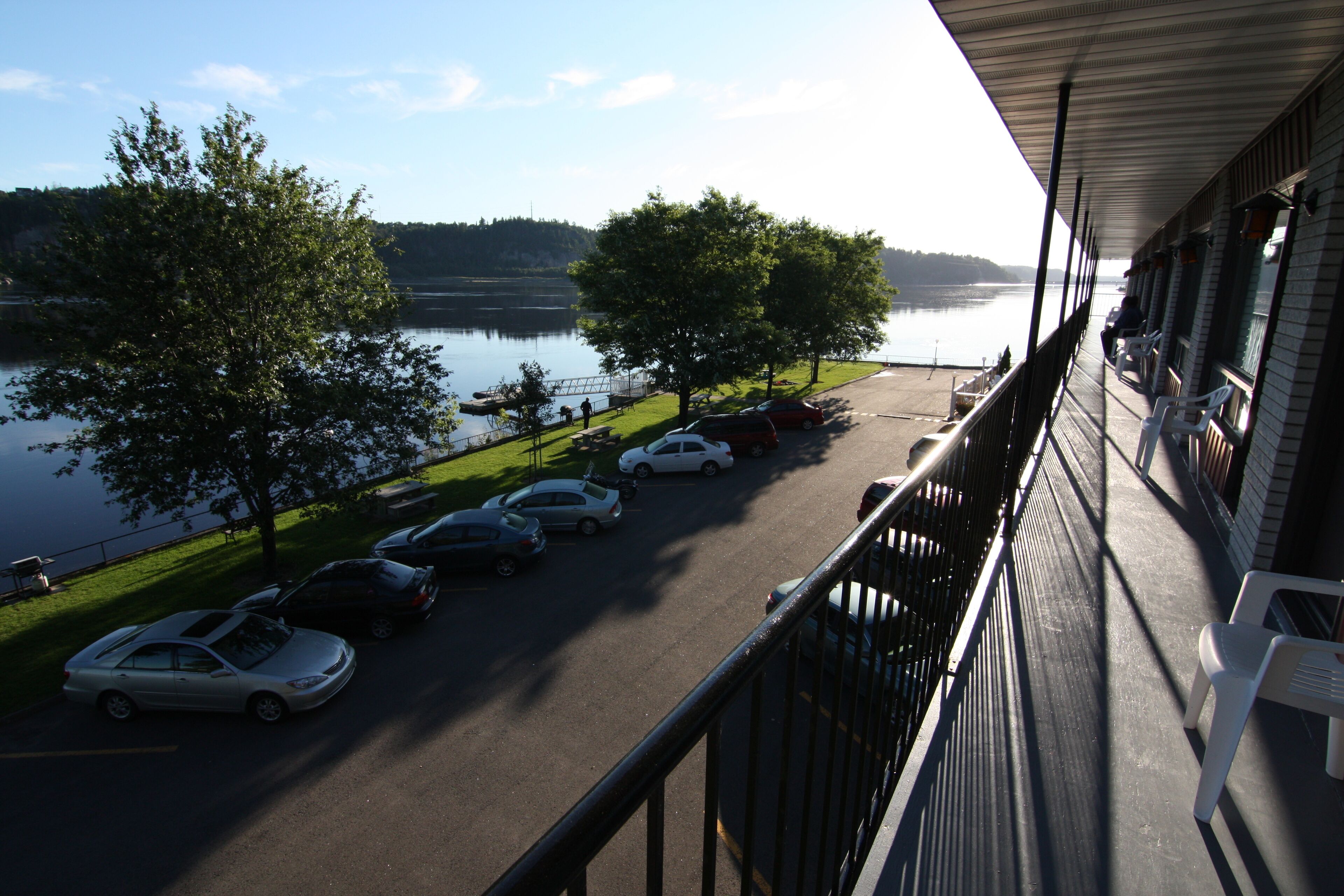 A balcony with a view of a parking lot and a lake.