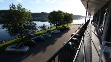 A balcony with a view of a parking lot and a lake.