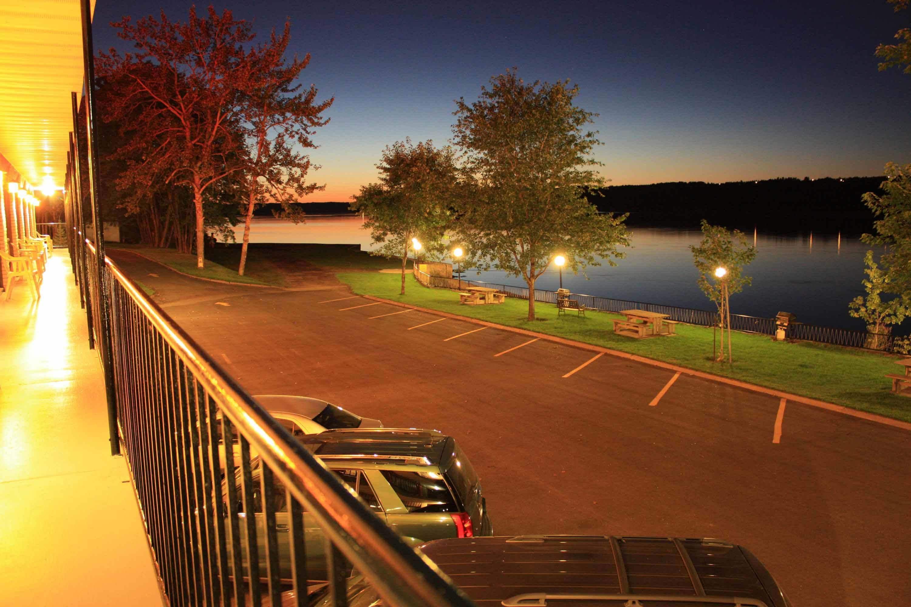 Un espace de stationnement offrant une vue sur un lac au crépuscule.