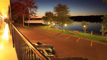 A parking area with a view of a lake at dusk.