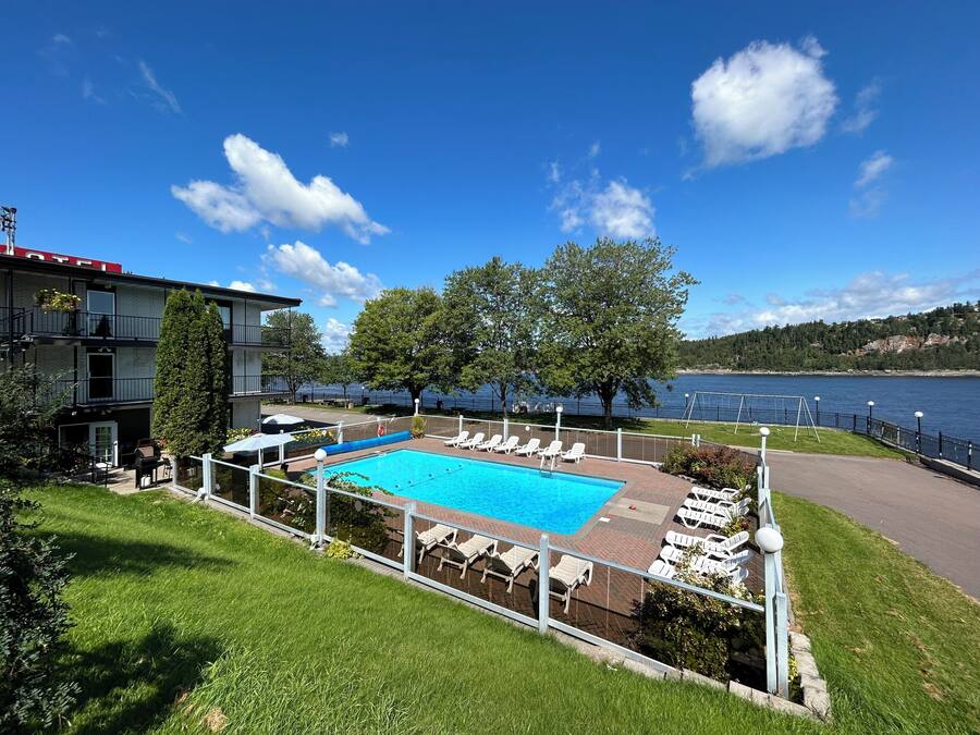 Una piscina al aire libre de temporada, sillones reclinables de piscina