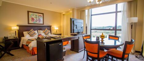 Una habitación de hotel con cama, escritorio y zona de comedor.