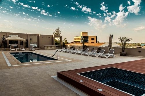 Una piscina techada, una piscina al aire libre, sombrillas