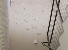 A staircase with beige walls and star-shaped wall decorations.