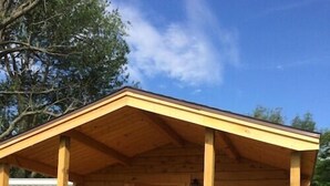 A wooden cabin with a porch, a door, and a window. - Duck Lake Campground (Red Creek)