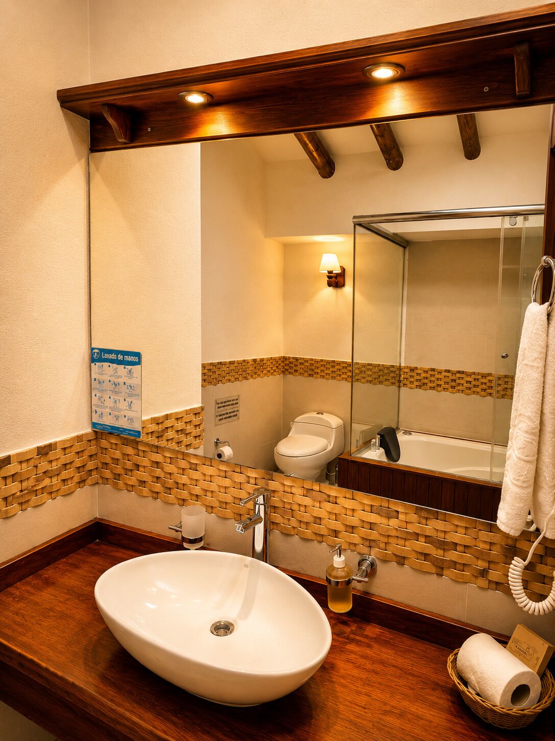 Un baño con un lavabo blanco, un espejo, un perchero para toallas y un inodoro.