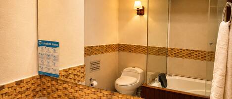 Un baño con un lavabo blanco, un espejo, un perchero para toallas y un inodoro.