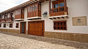 A traditional building with wooden balconies, large wooden doors, and a stone-paved street.