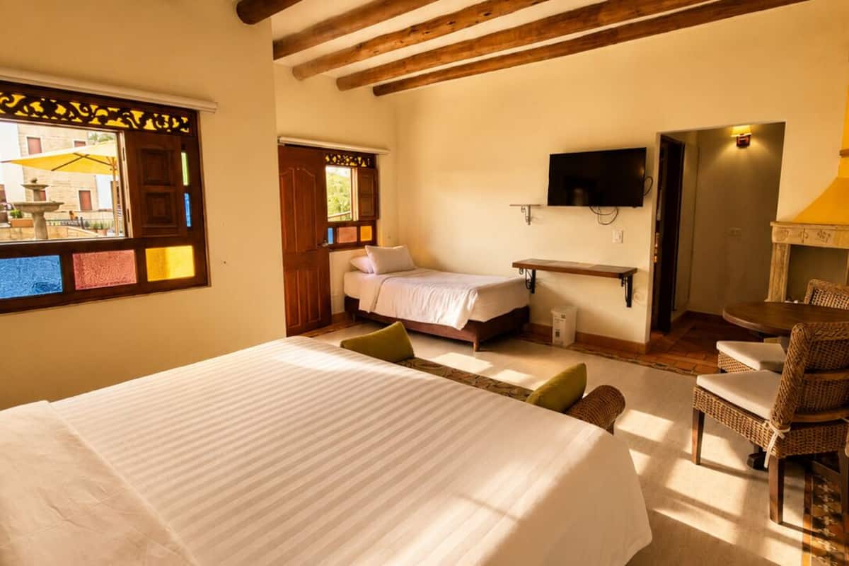 Ein Schlafzimmer mit einem großen Bett, einem Fernseher, einem Schreibtisch und einem Essbereich.
