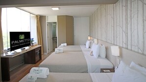 A hotel room with two beds, a desk with a TV, and a reception area. - Palmetto Hotel Business La Perla (Callao)