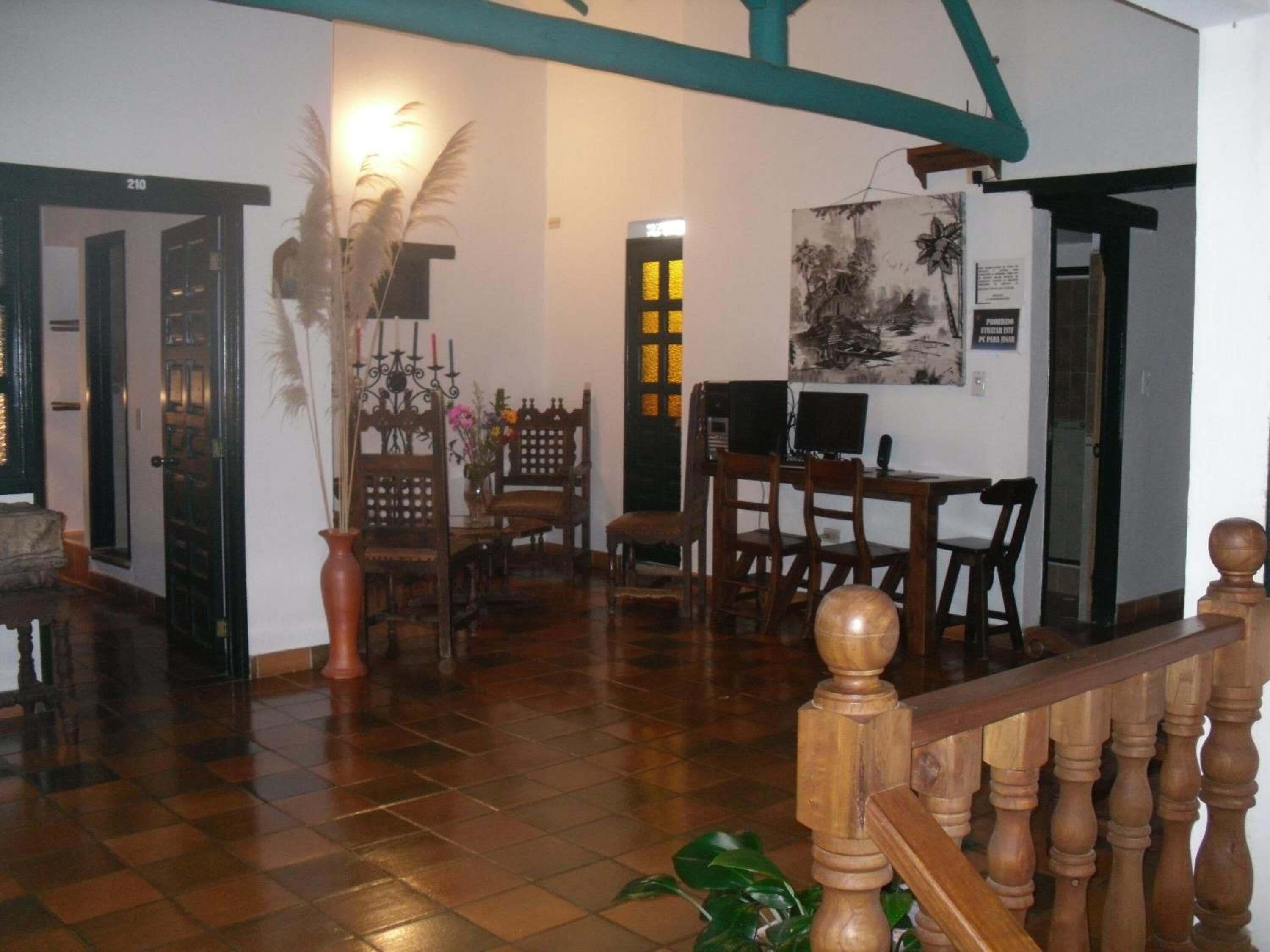 Una habitación amplia con piso de madera, un área de comedor con mobiliario de madera y una escalera con barandilla de madera.