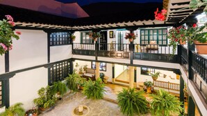 A courtyard with multiple levels, potted plants, and a fountain. - Hotel Antonio Nariño (Villa de Leyva)