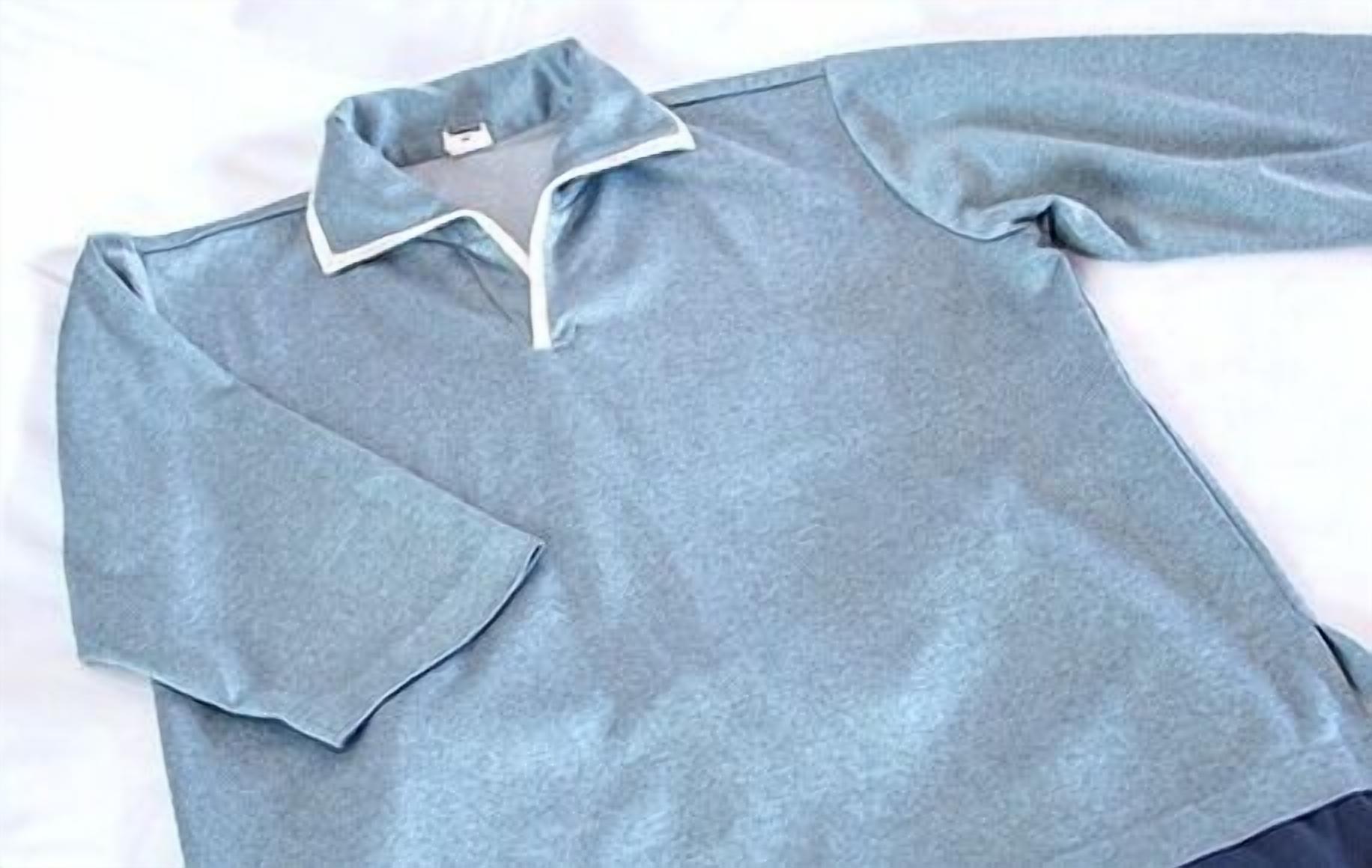 A light grey polo shirt with a collar and a pocket on the left side.
