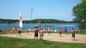 Un match de volleyball de plage avec des joueurs et des spectateurs.