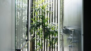 Un bany modern amb una porta de vidre que dona a un jardí de bambú.