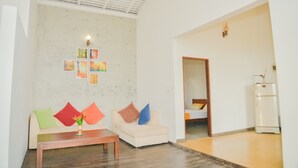A living room with a sofa, a coffee table, and a refrigerator. - Sandaya's Place (Unawatuna)