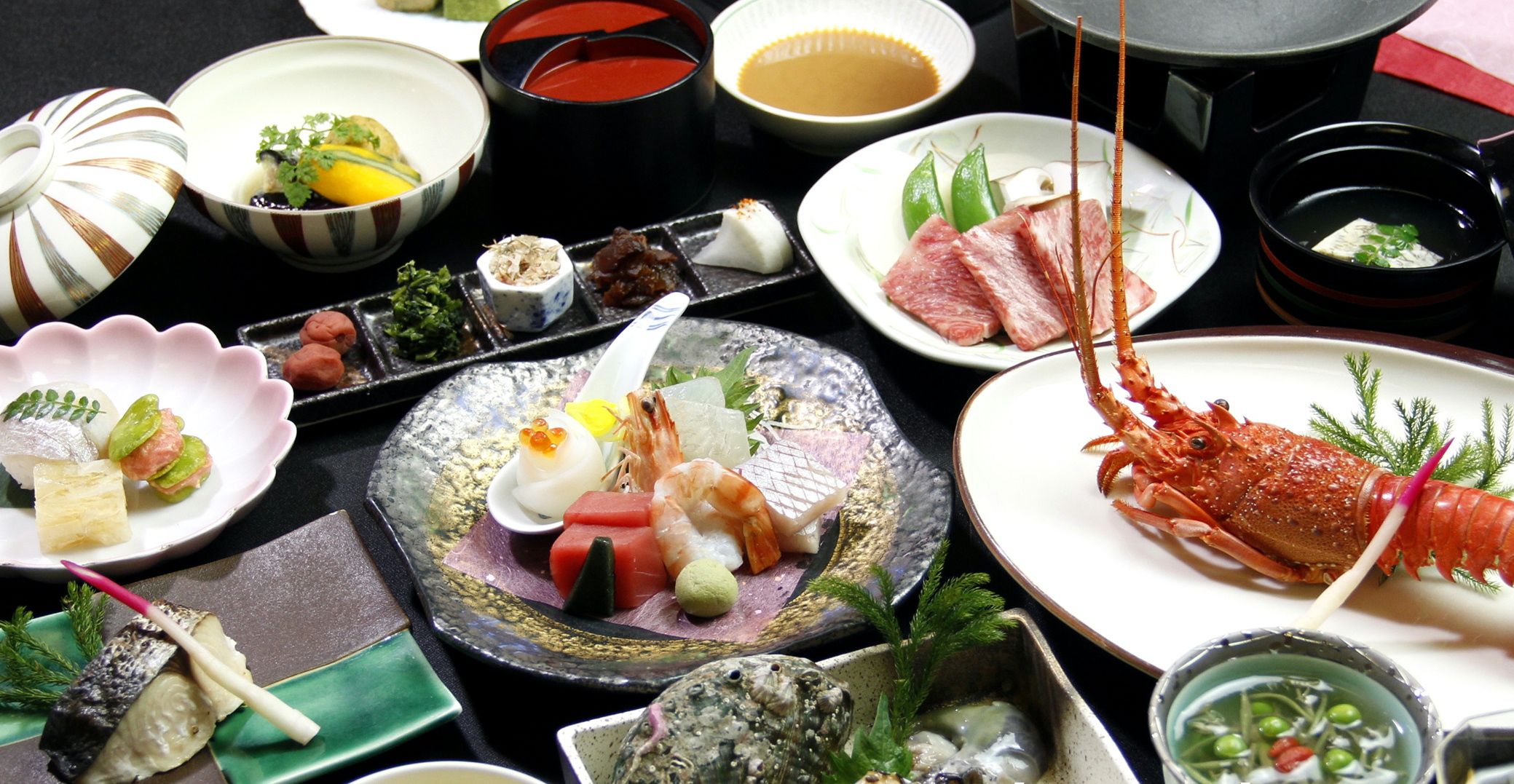 A variety of dishes including seafood, sashimi, and sushi on a table.