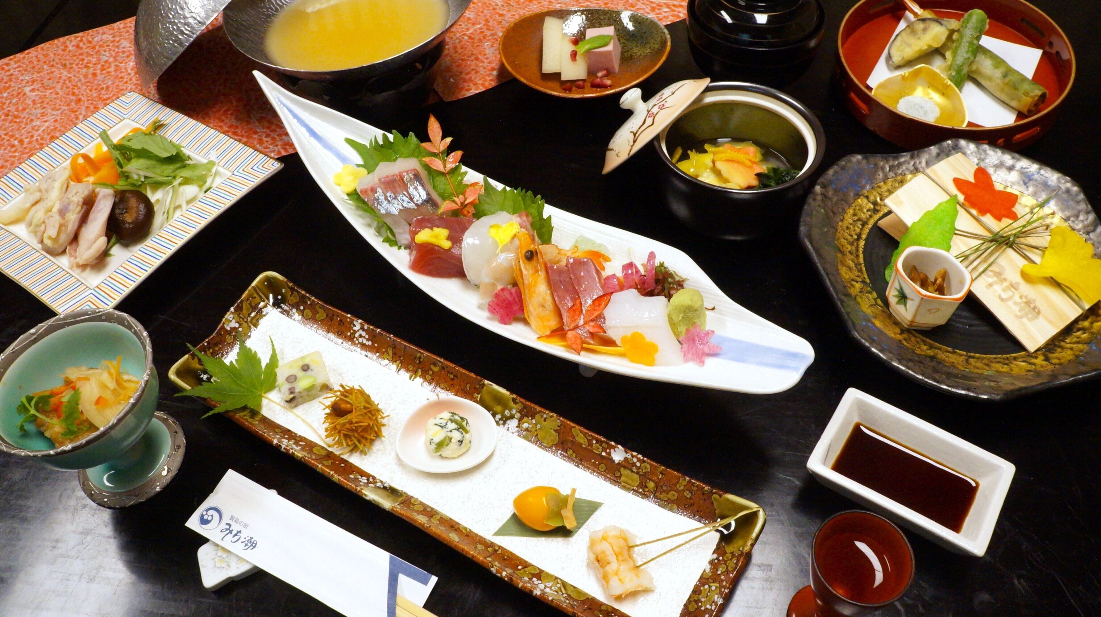 Variedad de platos japoneses sobre una mesa, incluyendo sushi, sashimi y otras exquisiteces, con salsas y pequeños recipientes de aderezo.