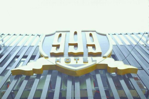 A hotel sign with a shield emblem and the word "HOTEL" below it.