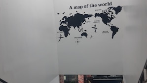 A world map wall decal on a white wall in a stairwell. - 999 Hotel (Angeles City)