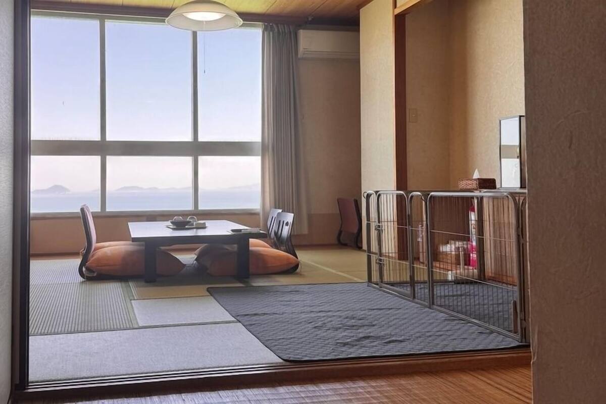 A traditional Japanese room with tatami flooring, a low table, and cushions.