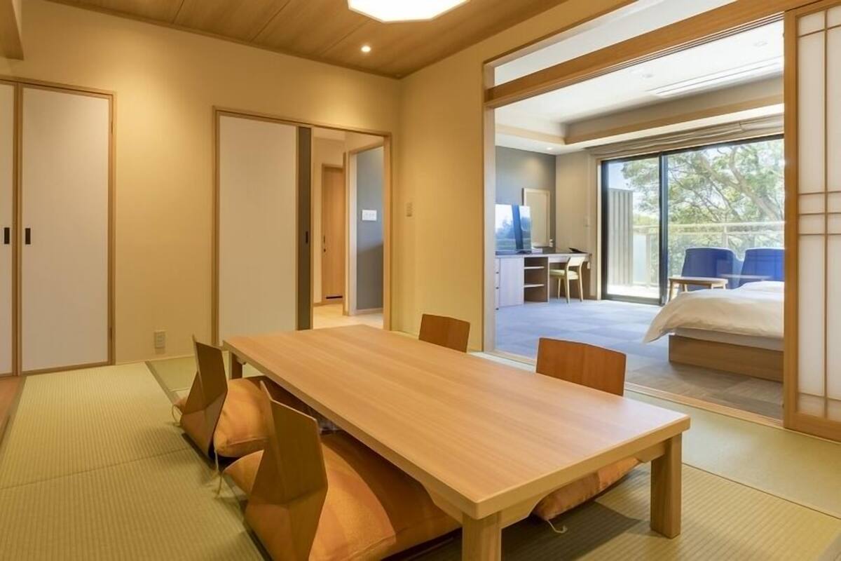 A traditional Japanese-style room with tatami flooring, a wooden table, and sliding doors.