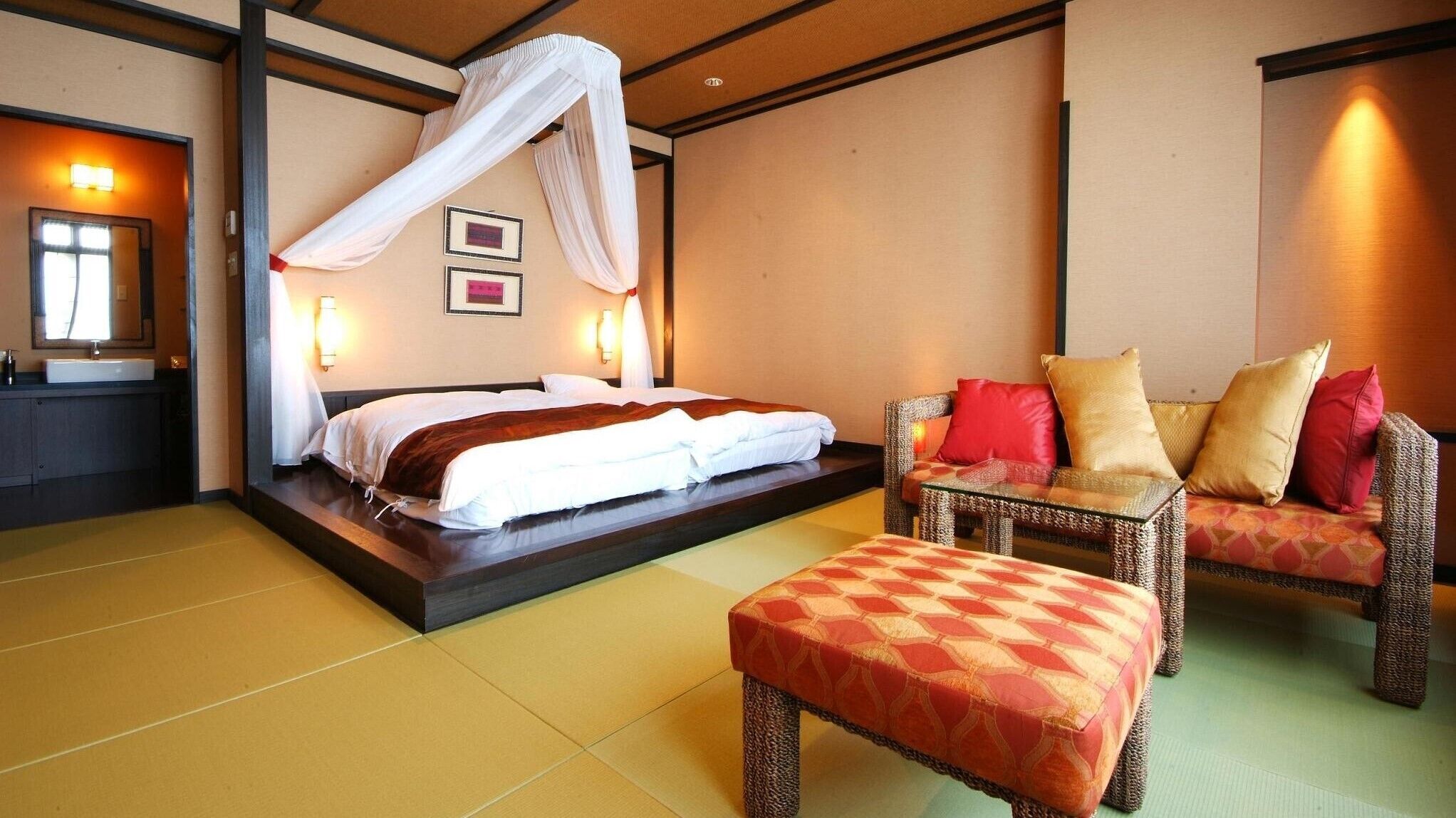A hotel room with a bed, a sofa, a chair, and a small table.