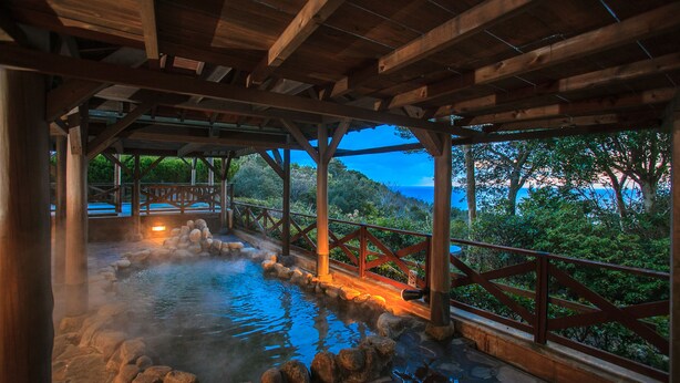 A wooden structure with a stone hot spring area, wooden railings, and a view of the ocean. - Ijika Daiichi Hotel Kagura (Toba)