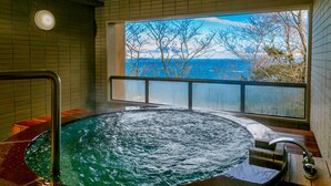 A hot tub with a view of the sea through a window. - Ijika Daiichi Hotel Kagura (Toba)