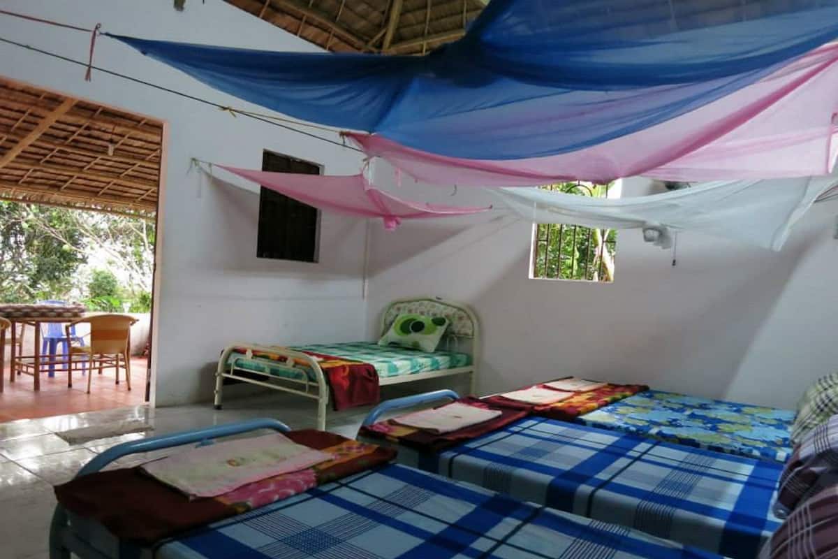 A room with two beds, a small table, and a chair.
