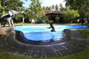 Una piscina al aire libre, sillones reclinables de piscina