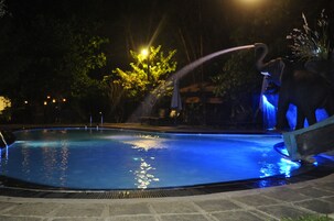 Una piscina al aire libre, sillones reclinables de piscina