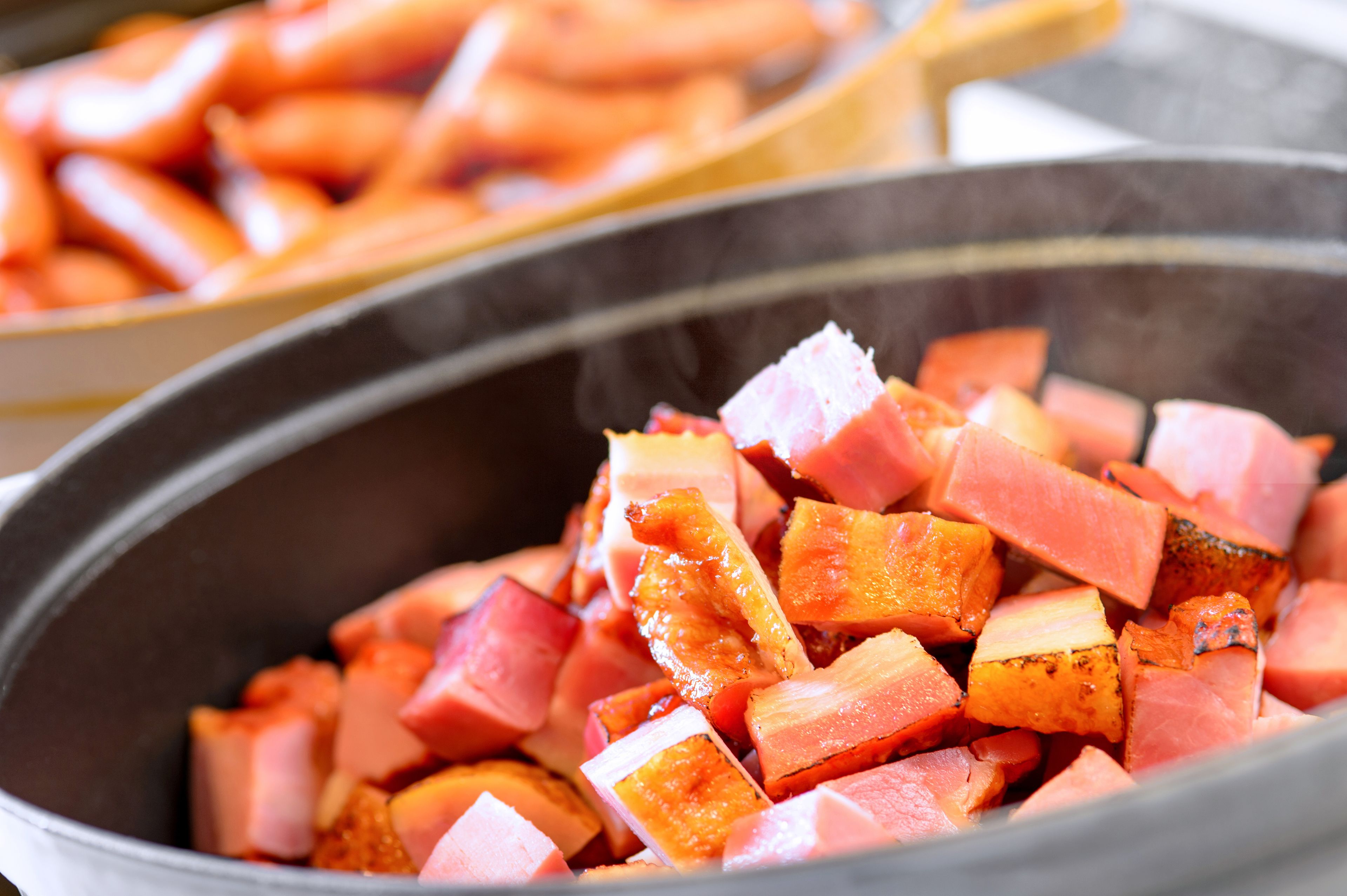 A close-up of diced ham in a pan.