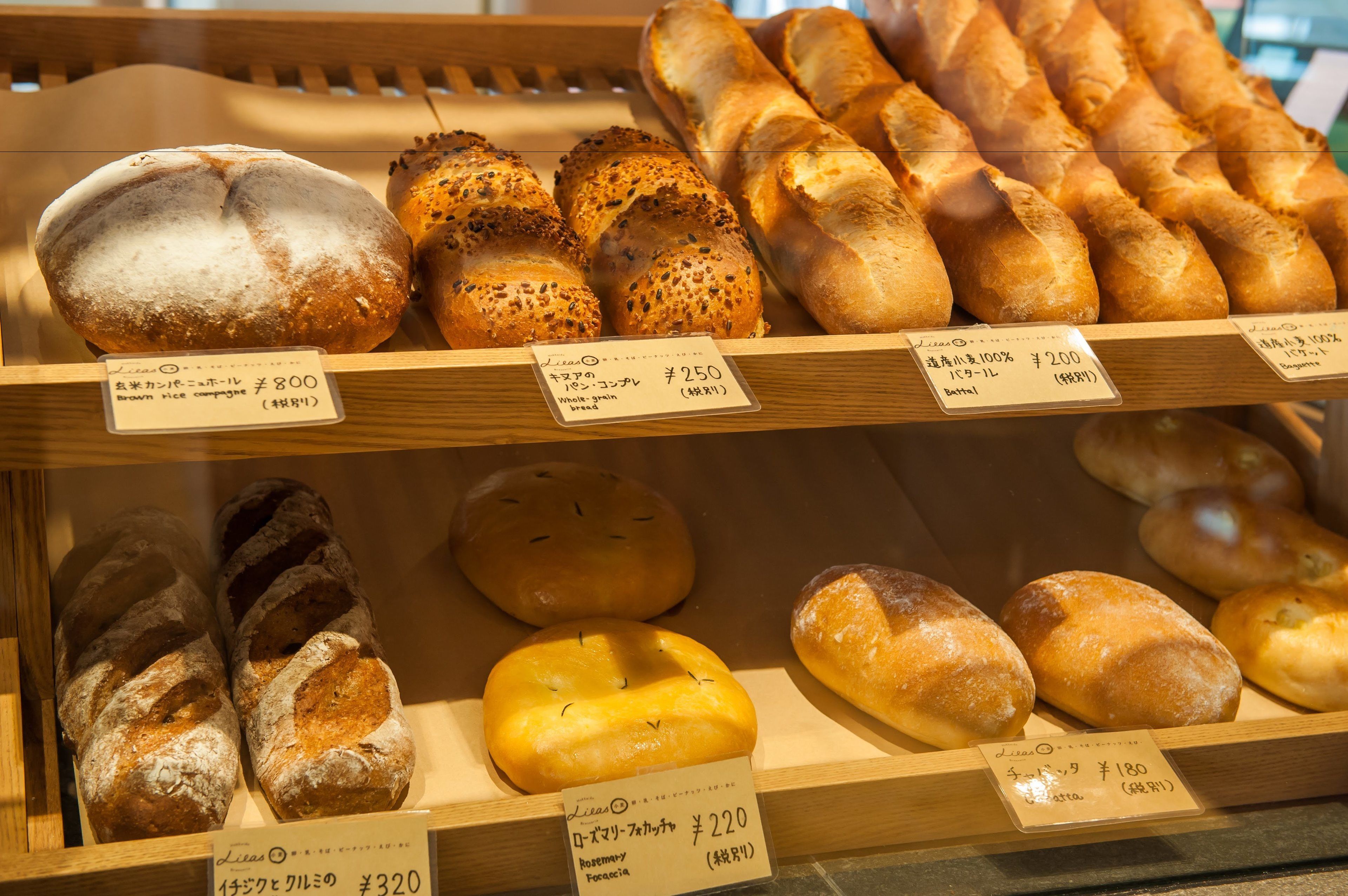 Una vitrina de panadería con panes y pasteles varios.