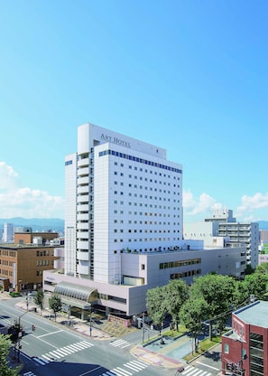 Un hôtel d’art moderne, caractérisé par une façade blanche imposante, de nombreux étages et un toit plat.