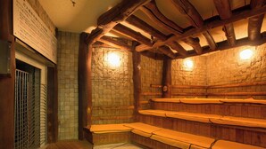 A traditional Japanese onsen with wooden benches and stone walls. - Art Hotel Asahikawa (Asahikawa)