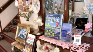 A display of books and a framed picture on a table with a decorative item and a lamp. - Pension Puppy Tail (Hakodate)