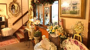 A staircase with ornate railings, a mirror, and a floral arrangement.