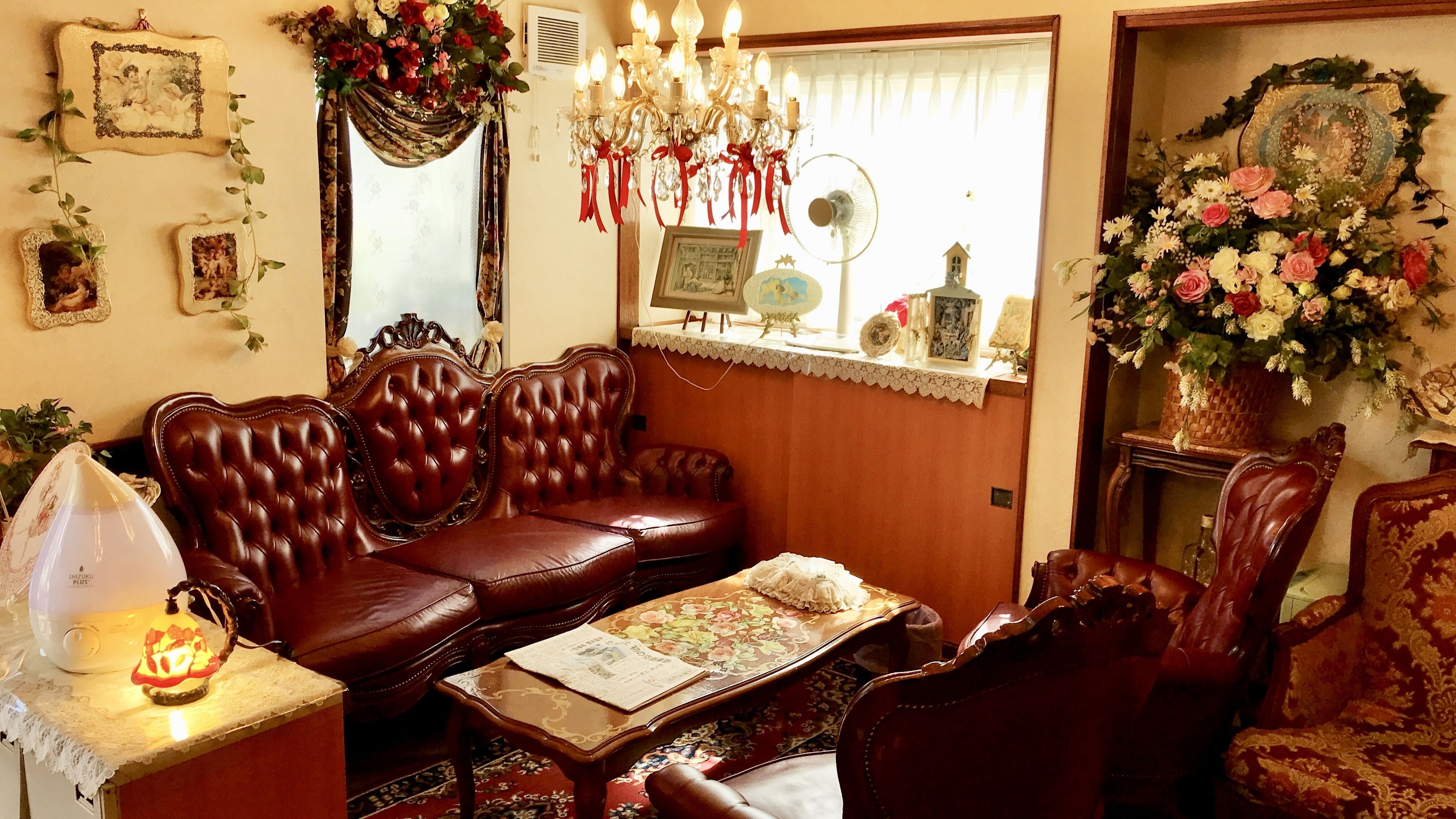 A traditional living room with a leather sofa, a wooden coffee table, and a chandelier.