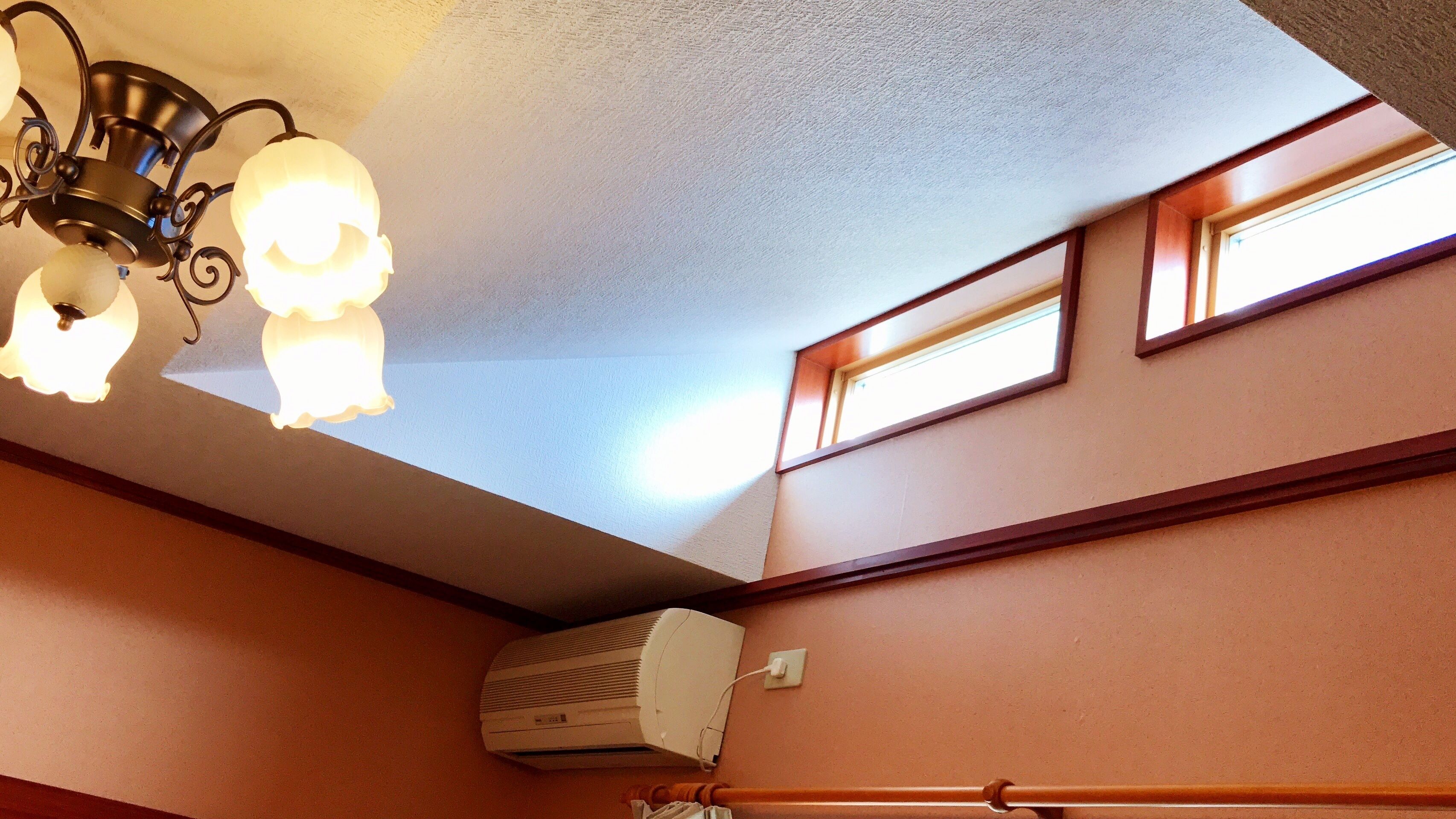 Una habitación con ventilador de techo, aire acondicionado y ventana con vista al cielo.