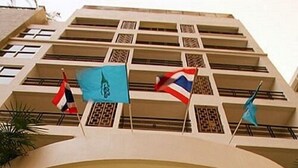 A hotel entrance with a glass facade, a marble archway, and flags on the balconies. - Summer Spring Hotel (Pattaya)