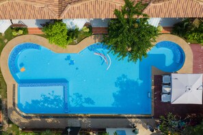 Una piscina al aire libre, sillones reclinables de piscina