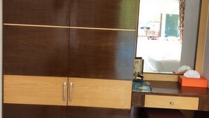 A wooden wardrobe with two drawers and a mirror above it. - Charm Resort Cha-am (Cha-am)