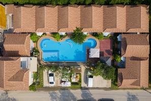 Una piscina al aire libre, sillones reclinables de piscina