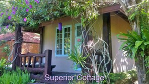 A rustic cottage with a wooden porch, a small window, and lush greenery surrounding it. - Bulun Buri Resort (Hang Dong)
