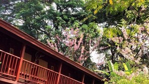 A wooden structure with a balcony, surrounded by lush greenery and flowering plants. - Bulun Buri Resort (Hang Dong)